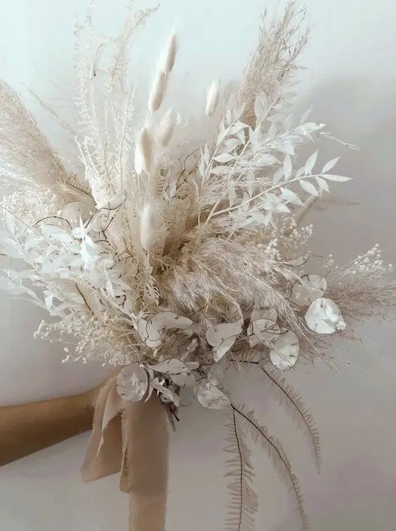 a pure white wedding bouquet of lunaria, bunny tails, pampas grass and some dried grasses and leaves plus tan ribbons is amazing