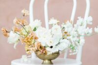 a refined and chic wedding centerpiece of white roses, white and peachy-colored sweet peas plus some white fillers is wow