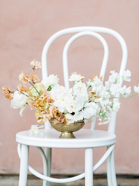 a refined and chic wedding centerpiece of white roses, white and peachy-colored sweet peas plus some white fillers is wow