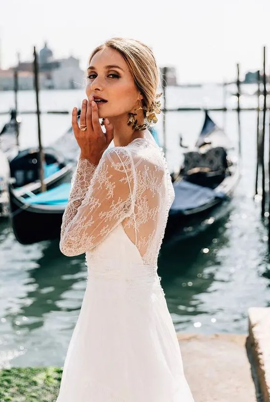 a refined birdal look with a lace wedding dress with an illusion back and statement black and gold flower earrings that wow