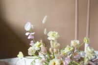 a refined dimensional wedding centerpiece of blush sweet peas, white blooms and bunny tails for spring or summer