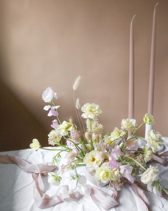 a refined dimensional wedding centerpiece of blush sweet peas, white blooms and bunny tails for spring or summer