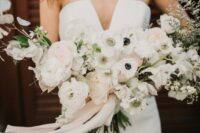 a refined wedding bouquet of blush and white ranunculus, anemones, lunaria and greenery is a stunning idea for a spring or summer wedding