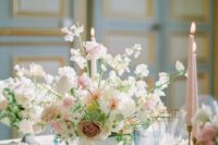 a refined wedding centerpiece of a white bowl, some white and blush sweet peas, blush and dusty pink roses