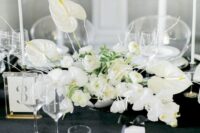 a refined white wedding centerpiece of orchids, anthuriums, ranunculus and twigs is a lovely and cool idea