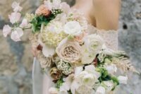 a romantic textural wedding bouque with blush and white blooms and some greenery for a spring bride