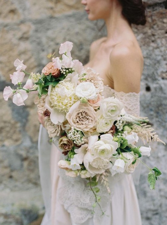 a romantic textural wedding bouque with blush and white blooms and some greenery for a spring bride