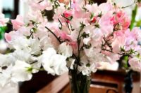 a simple and lush wedding centerpiece of white and pink sweet peas is a cool idea that you can repeat yourself