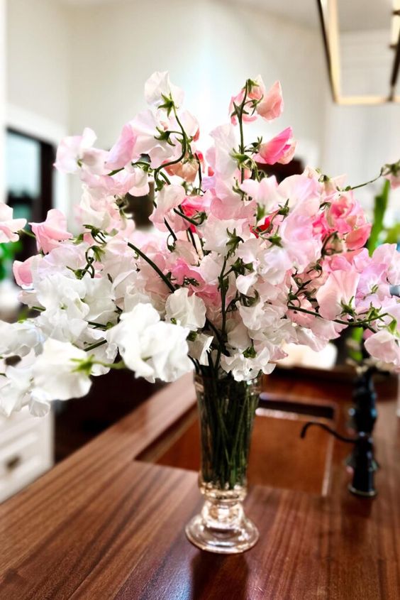 a simple and lush wedding centerpiece of white and pink sweet peas is a cool idea that you can repeat yourself