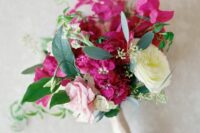 a small and lovely wedding bouquet of a white and pink rose, bougainvillea and greenery is a fun and cool idea for a summer wedding