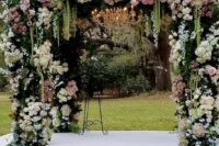 a sophisticated wedding arch covered with greenery, white and pink roses and green amaranthus is adorable for a garden wedding