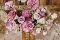 a sophisticated wedding centerpiece of a gold vase, pink and white roses, peonies and anthurium is amazing