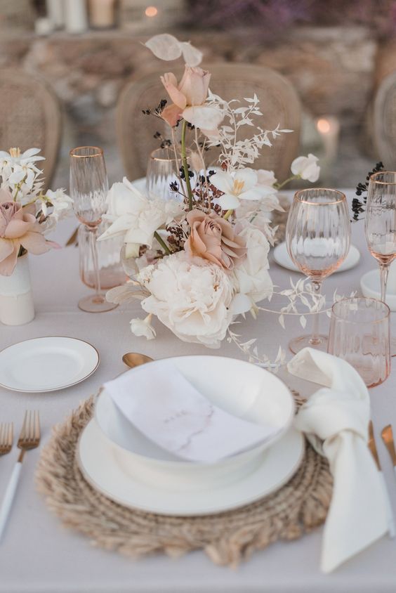a sophisticated wedding centerpiece of white peonies, peachy roses, lunaria and some white and dark foliage is a lovely idea for a boho wedding