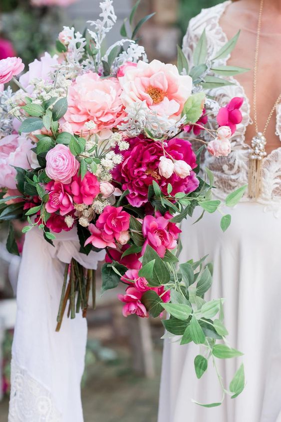 a stunning wedding bouquet of blush and pink peonies, pink ranunculus, bougainvillea, greenery and pale miller for a summer wedding