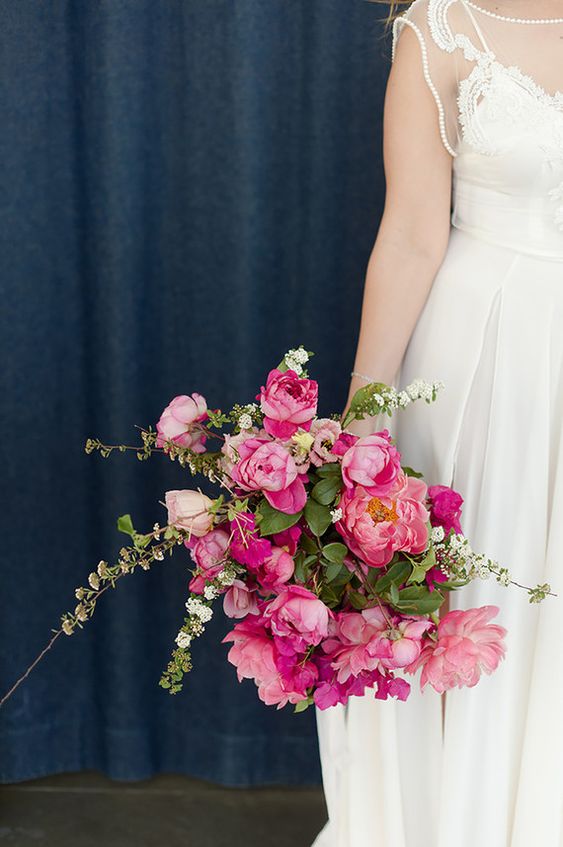 a stunning wedding bouquet of pink peonies and bougainvillea plus greenery and white fillers for a pink summer wedding