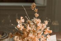 a stylish modern wedding centerpiece of peachy-colored sweet peas and some fillers is a lovely idea for spring or summer