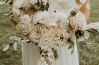 a subtle neutral wedding bouquet of roses, dahlias and peonies, lunaria, greenery and thistles is a lovely idea for a summer bride