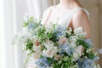 a subtle wedding bouquet of blue sweet peas, blush roses, some white fillers and greenery for a spring or summer bride