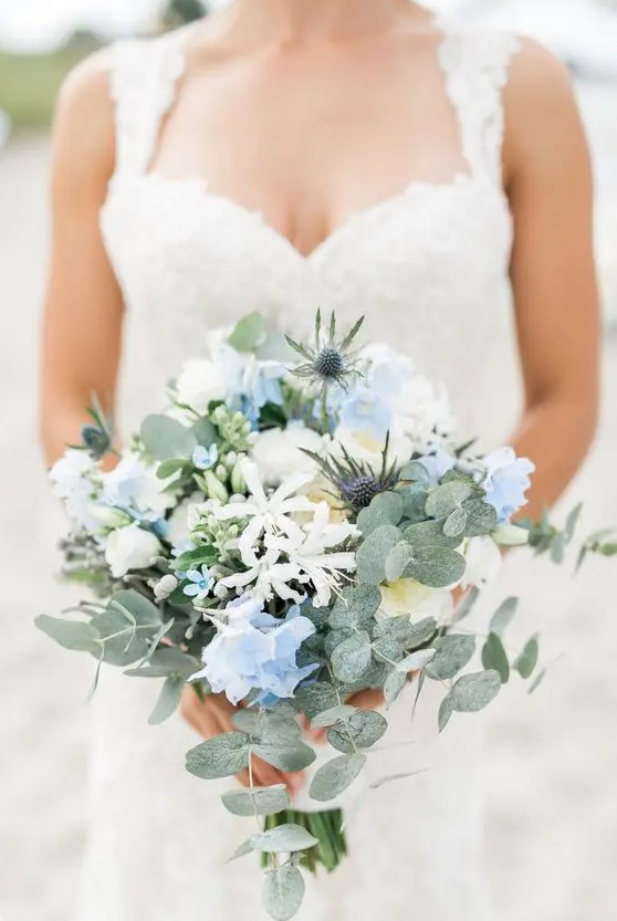 a subtle wedding bouquet of white and serenity blue flowers, thistles, greenery is a chic and delicate idea for a spring wedding