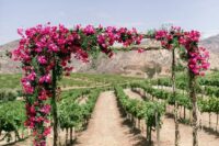 a super bright and lush wedding chuppah covered with bougainvillea and greenery is a fun and cool solution for a colorful wedding