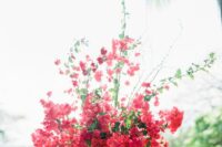 a super lush and dimensional wedding centerpiece of a vintage urn, bougainvillea nd greenery is a stunning idea for summer