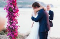 a super lush wedding arch covered with bougainvillea and greenery is a fantastic idea for a Mediterranean wedding