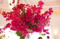 a tall wedding centerpiece of bold bougainvillea, greenery is a stunning idea for a colorful wedding in summer