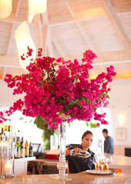 a tall wedding centerpiece of bold bougainvillea, greenery is a stunning idea for a colorful wedding in summer