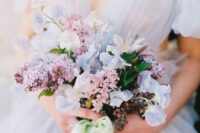 a tender wedding bouquet of lilac, blue sweet peas, some greenery is amazing for a pastel spring wedding