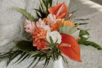 a tropical wedding bouquet of blush and orange blooms, anthurium and greenery is a cool idea for a wedding