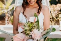 a tropical wedding bouquet of blush anthurium, dahlias, king proteas, greenery and leaves plus air plants