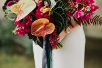 a tropical wedding bouquet of oversized tropical leaves, anthurium, bougainvillea is a stunning and chic idea for a tropical wedding