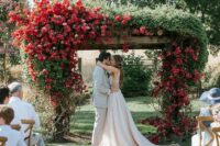a unique wedding arch of wood with greenery and bougainvillea covering it looks absolutely gorgeous