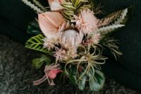 a unique wedding bouquet of blush and white anthurium, king proteas, dahlias, greenery and air plants