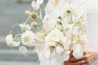 a unique white wedding bouquet of lunarias, white blooms and various dried herbs for an airy look
