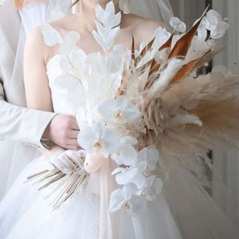 a wedding bouquet of orchids, dried leaves, lunaria, pamps grass and leaves is a cool and bold modern wedding idea