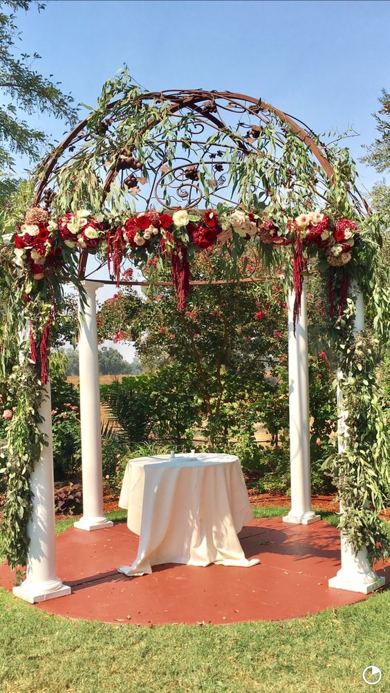 A wedding chuppah with greenery, white and burgundy blooms plus amaranthus is a refined vintage inspired idea