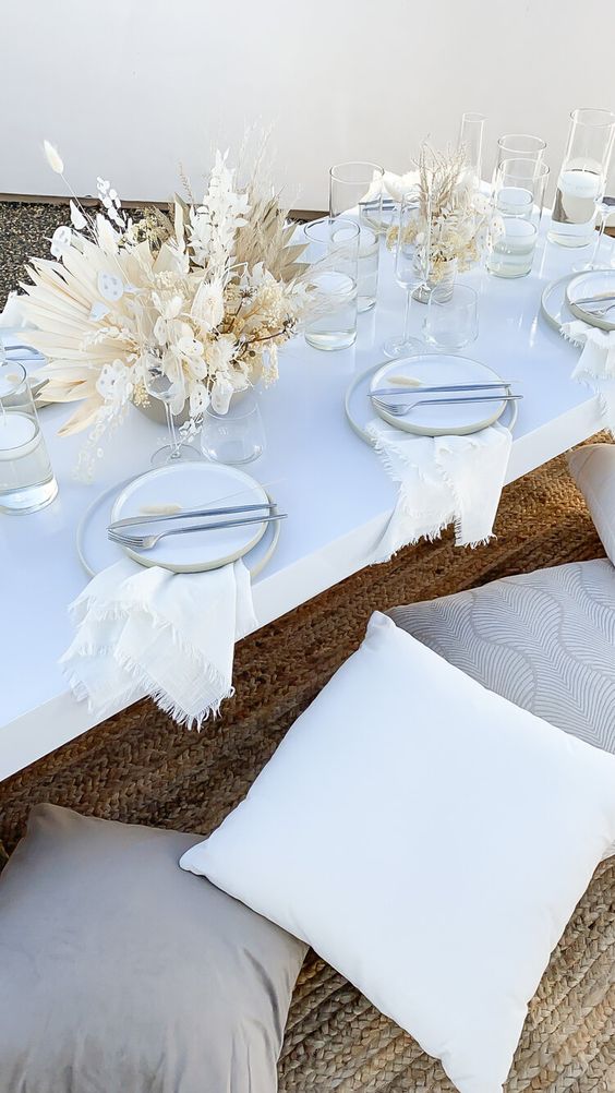 a white boho wedding centerpiece of lunaria, dronds, dried leaves and blooms plus bunny tails is a lovely neutral wedding idea