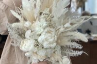 a white wedding bouquet of peonies, lunaria, grasses and leaves plus bunny tails is a chic and cool idea with many dried elements