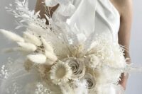 a white wedding bouquet of roses, seed pods, dried leaves and grasses, lunaria and baby’s breath is a chic and cool solution