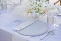 a white wedding centerpiece of a bowl, some pampas grass and white sweet peas is a cool idea for an elegant white wedding