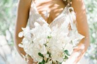 an airy lunaria and berries wedding bouquet with a sheer white ribbon is a beautiful and breezy idea