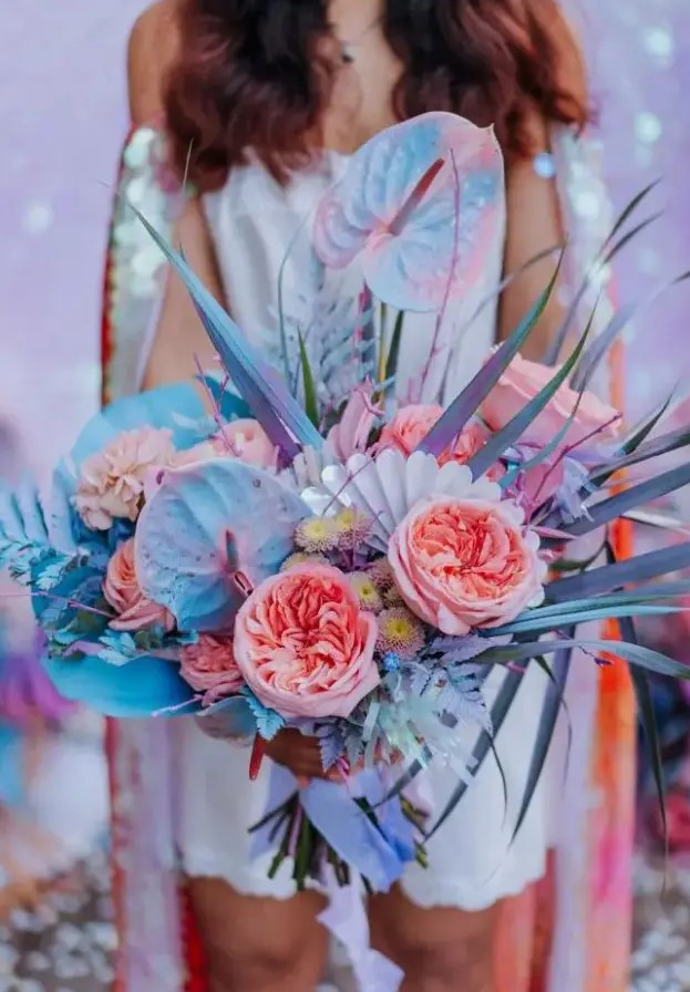 an amazing iridescent wedding bouquet with pink, blue, lilac blooms, grasses and fronds and with iridescent elements is wow