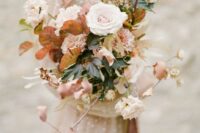 an earthy-colored wedding bouquet of blush roses and carnations, mums, sweet peas, greenery and bold fall foliage