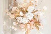 an elegant wedding bouquet of white roses, blush lunaria, gilded leaves and berries and some fabric blooms is a creative solution