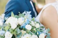 an eye-catching wedding bouquet of white and blue blooms and greenery is a lovely idea for a wedding