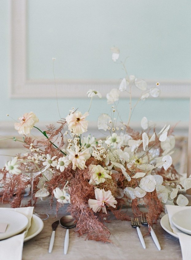 an unusual wedding centerpiece of carnations, lunaria, wispy rust-colored fern is a gorgeous solution for a fall wedding