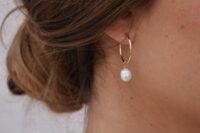 classy modern bridal earrings with gold hoops and pearls hanging on them will finish off a modern bridal look