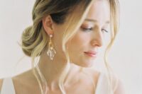 delicate and subtle gold earrings with crystal pendants to add a chic and subtle touch to the look