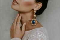jaw-dropping statement gold earrings with oversized blue stones for a bold statement and a touch of color